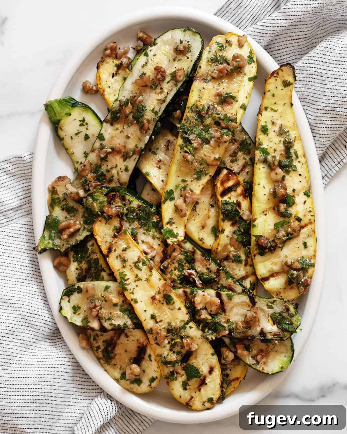 Grilled zucchini and squash on an oval serving plate.