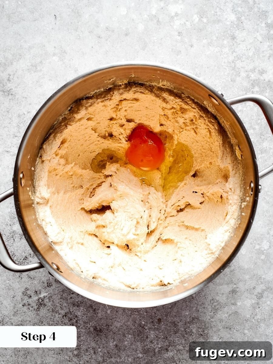 A room-temperature egg blends in smoothly, binding the oatmeal cream pie dough without breaking the emulsion.