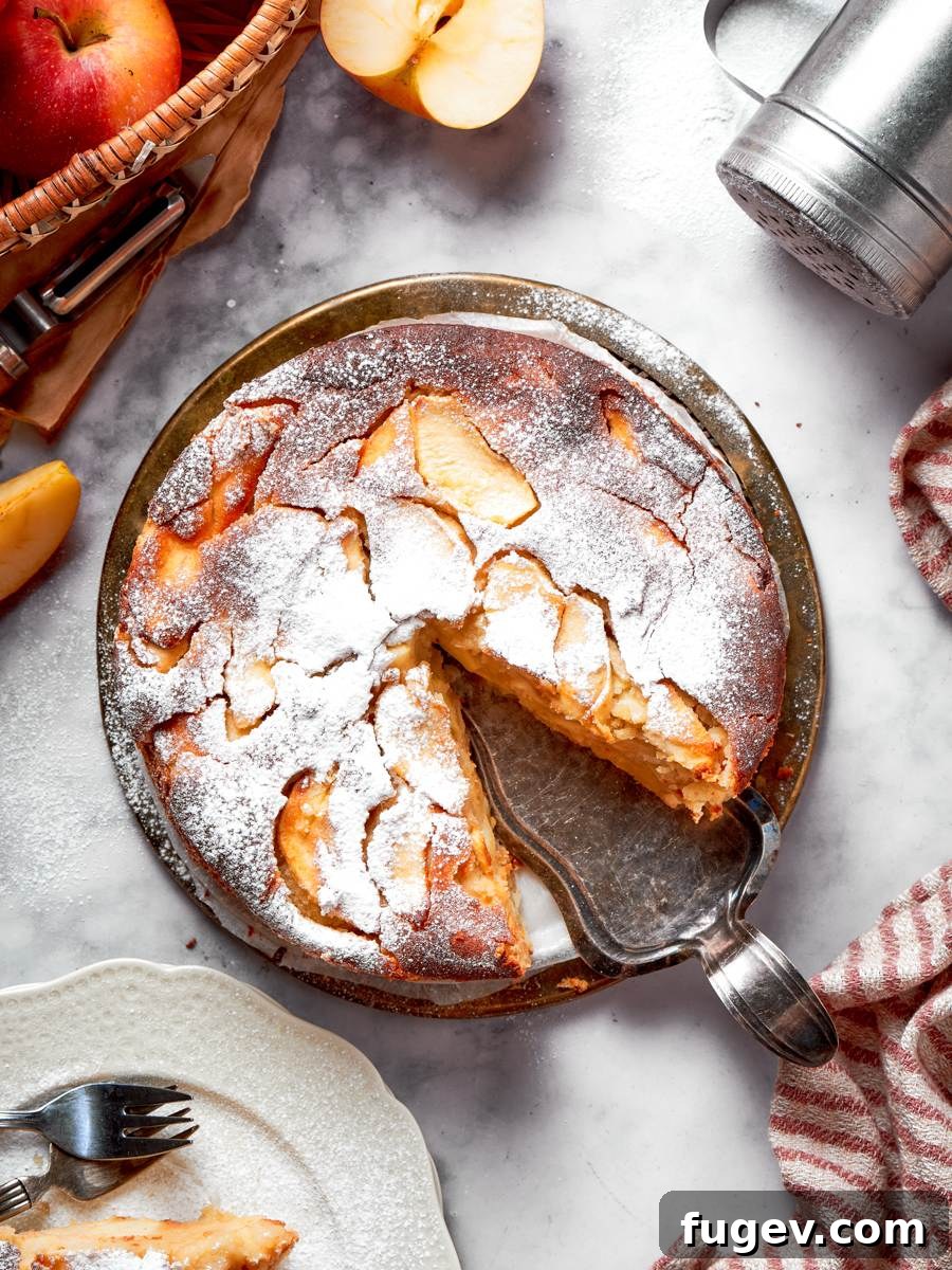 Classic French Apple Cake Recipe 2 Removing the first slice shows the frangipane-like interior that makes this french apple cake unforgettable.