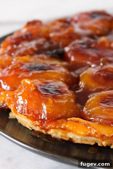 Classic French Apple Cake Recipe 13 Apple Tarte Tatin on black plate.